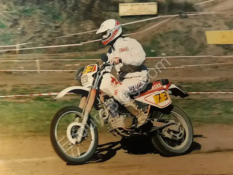 Vintage enduro blogger riding a 1986 Yamaha TT 600 during a taped special stage, classic off-road motorcycle in action, front three-quarter, in daylight. Viterbo, Italy.