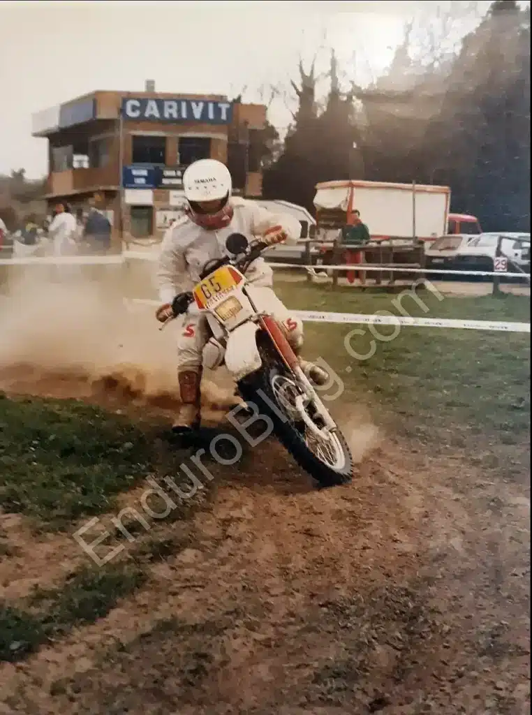 Vintage enduro blogger riding a 1976 Yamaha TT 600 during a taped special stage, classic off-road motorcycle in action, front three-quarter view while turning right in daylight.Viterbo, Italy.