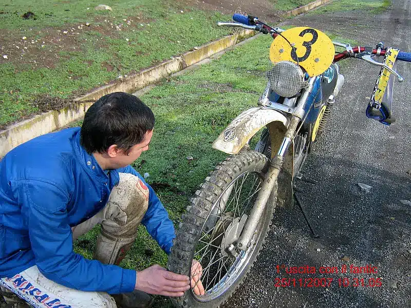 Enduroblog blogger is checking the air pressure on fantic motor caballer 50 cc 1975 front wheel, along the path.