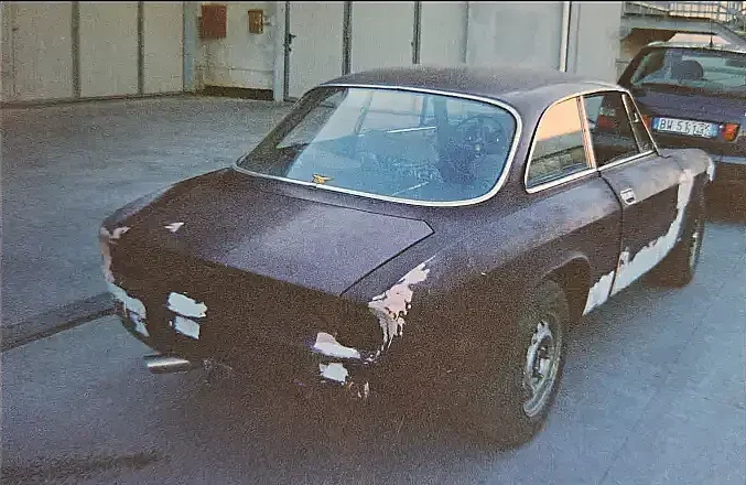 An Alfa Romeo GT Junior 1300 cc dark red colour during restauration. Some parts are missing. Rear three-quarter shot.