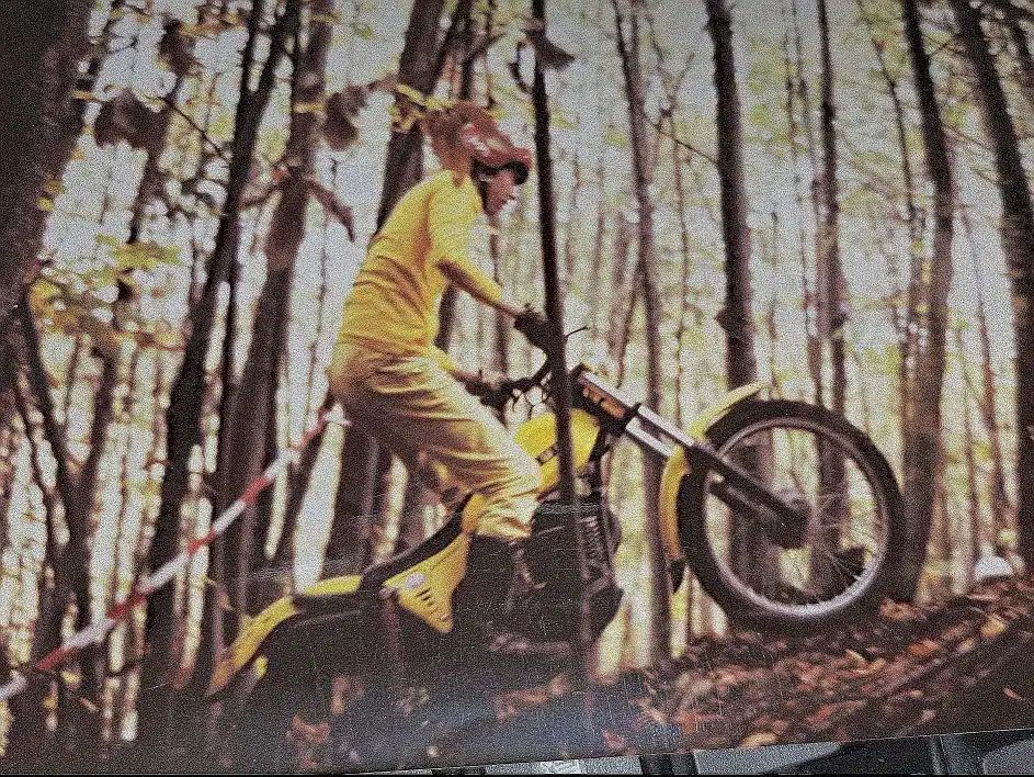 SWM TL 320 trial motorcycle, yellow colour, in the forest, climbing a hill.